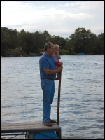 Photo of grandfather and granddaughter watching boats from the dock