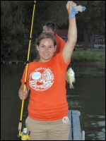 Photo of a woman with a fish she just caught off the dock