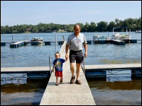 Photo of grandfather and grandson walking on the dock